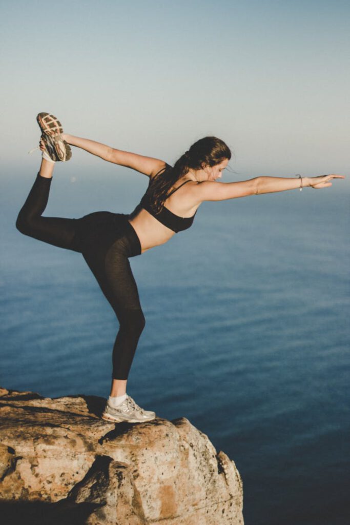 pexels-photo-963697 Woman practicing yoga in Dancer's pose on a cliff with ocean view, Cape Town.